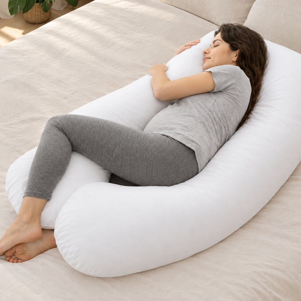Woman asleep hugging a U-shape pillow